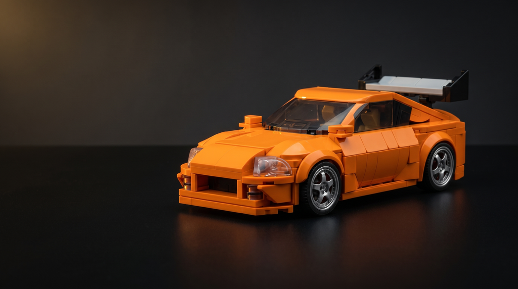 Orange brick-built Japanese sports car model on a dark desk